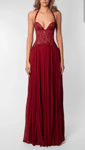 Close-up of red halter dress with lace bodice and pleated skirt details.