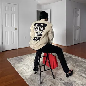 Detailed back view of women's apricot jacket with 'WATCH YOUR BACK' graphic print