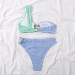 Vista detallada del conjunto de bikini con decoración de concha y tela ondulada.