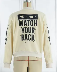 Detailed back view of apricot bomber jacket featuring black 'WATCH YOUR BACK' graphic print