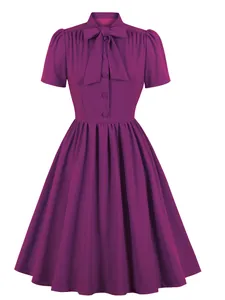 Frontal view of the elegant purple dress showing the pleated skirt and bow tie neckline