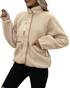 Detailed view of women's beige sherpa fleece jacket with functional zipper pockets