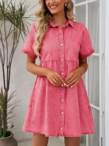 Détail de la robe en jean délavé rose avec taille à volants et boutons