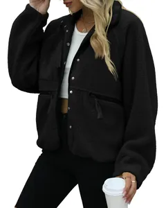 Detailed view of women's black sherpa fleece jacket with snap buttons and zippered pockets
