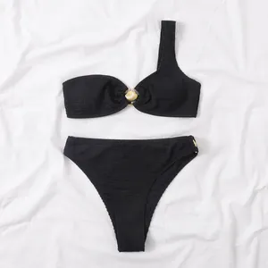 Conjunto de bikini negro de un hombro con tejido texturizado y detalle de concha dorada