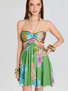Close-up detail of a vibrant green French floral print halter dress with stylish waist cut-outs