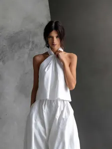 Elegante witte mouwloze haltertop en set met een wijde broek met hoge taille voor zomer.