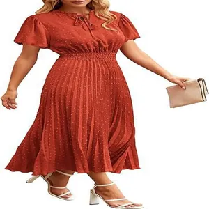 Detailed view of rust red Swiss dot midi dress with pleated skirt and elegant V-neck tie