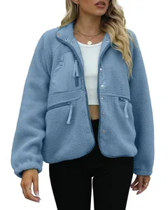 Close-up of women's blue sherpa fleece jacket with zipper pockets and snap buttons