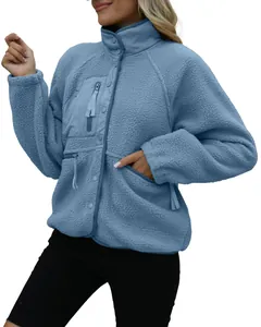 Detail view of a cozy blue sherpa fleece jacket with a high neck and snap buttons