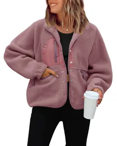 Detailed view of a pink women's sherpa fleece jacket with snap buttons and zip pockets.