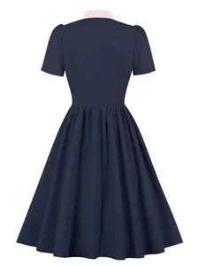 Back view of an elegant navy blue vintage A-line dress with a contrast pink collar