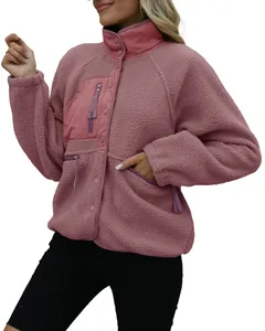 Close-up of pink sherpa fleece jacket featuring textured fabric and functional zip pockets