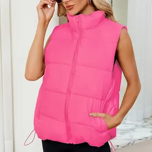 Close-up detail of a bright pink women's puffer vest with stand collar worn by a model