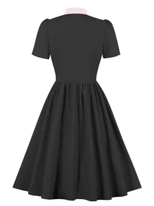 Back view of a black A-line dress featuring a contrasting pink collar and short sleeves.