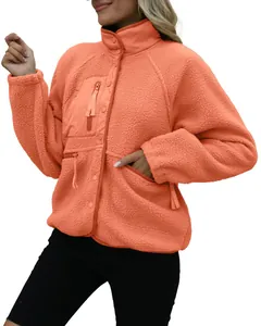 Close-up of women's orange sherpa fleece jacket with zipper and pocket details