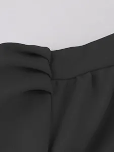 Detailed macro shot of black dress fabric showing fine texture and waistband stitching
