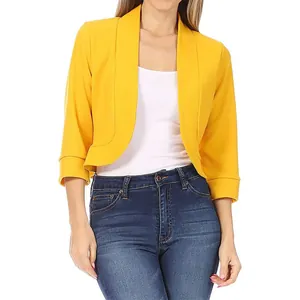 Détail d'un blazer court jaune vif pour femme, porté avec un jean en denim bleu.