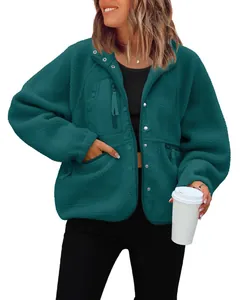 Close-up of dark teal fleece jacket detailing the chest pocket and button closure