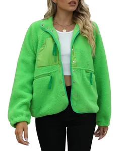 Close-up of vibrant green women's fleece jacket featuring snap buttons and zipper pockets