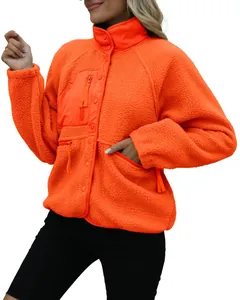Detailed view of women's vibrant orange sherpa fleece jacket with zip chest pocket