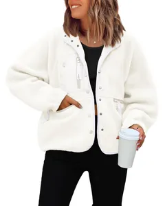 Close-up of women's white sherpa fleece jacket with zipper pockets and snap buttons