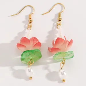 Detailed close-up of handmade lotus flower dangle earrings with elegant pearl drops