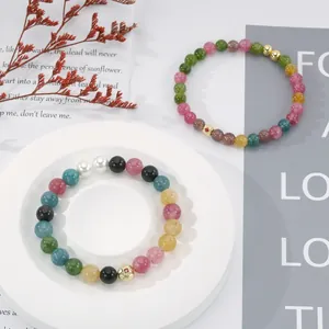 Detail shot of colorful tourmaline beaded bracelets with gold accents.