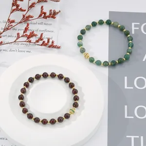 Detailed shot of handmade beaded bracelets with semi-precious stones and gold charms.