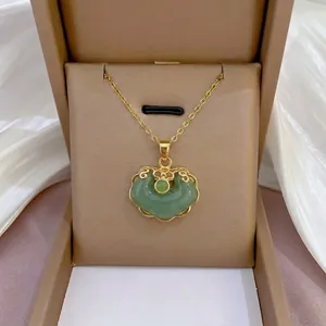Elegant gold titanium steel necklace with a green Ruyi peace lock pendant in a gift box.