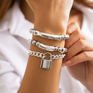 Close-up detail of fashionable silver-tone beaded bracelet set featuring a lock pendant charm
