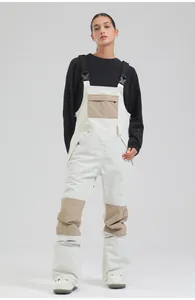 Professional waterproof women's ski bib pants in white and beige patchwork style.