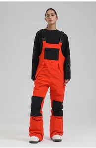 Full view of professional women's orange ski bib overalls on a model for winter sports