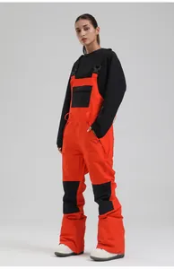 Front detail of bright orange women's ski bibs with black reinforced knee patches