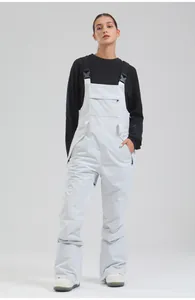 Professional women's white waterproof winter ski bib pants shown in full length studio view