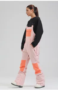 Side view of women's professional pink and orange bib ski pants for winter sports.
