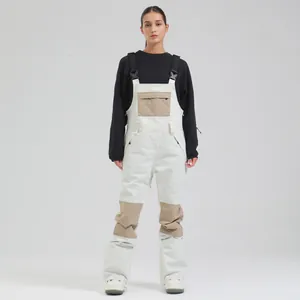 Professional women's white waterproof ski bib pants with tan knee patches for winter sports