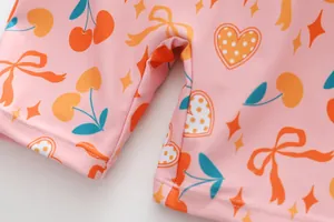 Detailansicht eines rosa Kinderbadeanzugs mit Kirsch-Herz-Druck und hochwertiger Naht