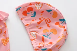 Detailansicht der rosa Mädchen-Badekappe mit süßen Kirsch- und Herzmustern für Kinder.