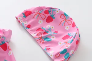 Nahaufnahme der rosa Badehaube für Mädchen mit süßem Erdbeer- und Schleifenmuster