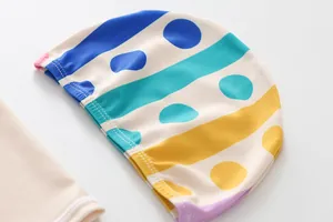 Detail of colorful striped and polka dot pattern on kids swimming cap