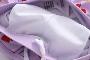 Close-up of soft white mesh lining and drawstring on girls' purple swimwear