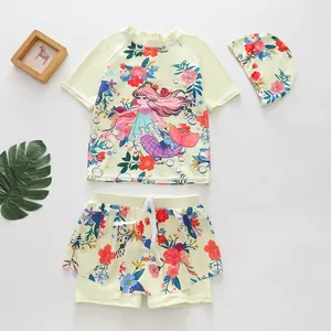 Three-piece girls mermaid swimsuit set with floral print top, skirted bottom and cap.