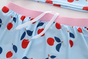 Close-up detail of cherry print and white drawstring on blue girl's swimwear bottoms