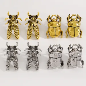 Primo piano di orecchini a forma di insetto color oro e argento dal design creativo