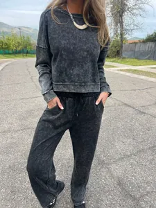 Model wearing a vintage black acid-wash tracksuit set with round neck and drawstring pants.