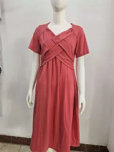 Close-up detail of a pink short-sleeved midi dress with a unique criss-cross wrap design