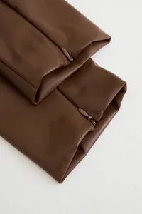 Vue détaillée du poignet d'une robe en similicuir marron avec fermeture éclair