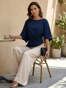 Vista dettagliata di elegante camicetta blu navy e pantaloni beige a gamba larga su modella