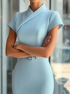 Détail d'une robe bleu clair élégante avec encolure croisée et boucle de ceinture.